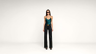 Woman in sunglasses wears a teal tank top, black flared pants, and black heels, standing against a plain white background.
