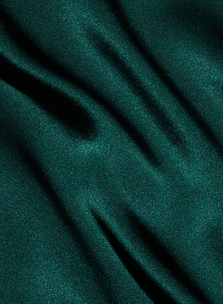 The Lexi Silk Camisole features emerald green, bias-cut silk with a soft, shiny texture and gentle diagonal folds that create depth and movement.
