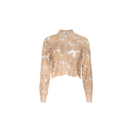 The Seychelle Cropped Eyelet Blouse is a beige, long-sleeve top featuring a collared neckline, button front, and intricate floral lace detailing over sheer fabric, finished with a cropped silhouette and shown against a plain white background.