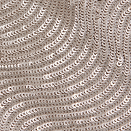 Close-up of the Rogan Sequin Top, featuring party-ready, shiny silver sequins sewn in swirling wave-like patterns on a light fabric background.