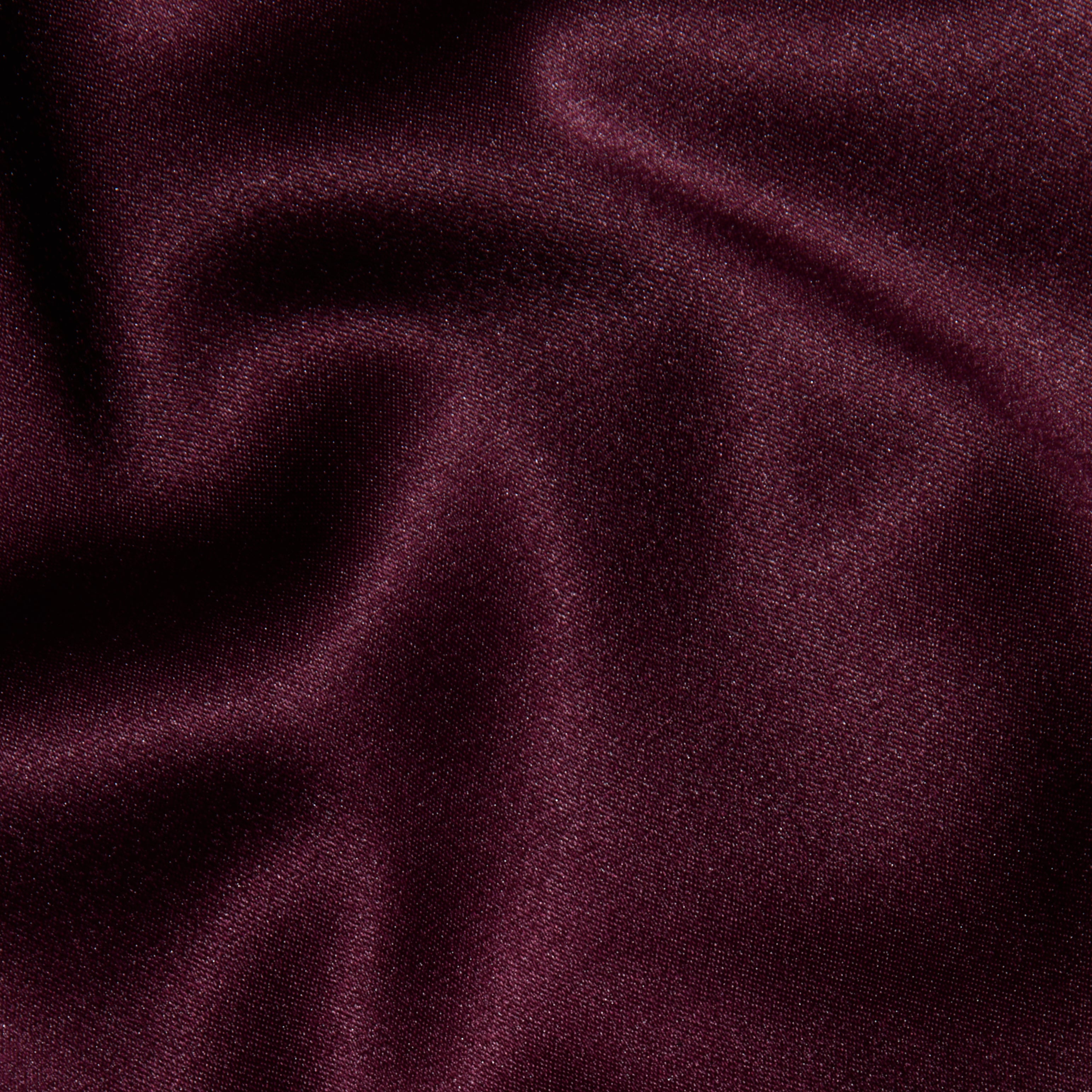 Close-up of smooth, deep burgundy fabric with soft folds and a subtle sheen, highlighting the luxurious and elegant appearance of the Dara Stretch-Satin Bodysuit with adjustable straps.