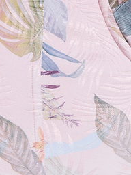 Gros plan sur le bustier Sonya, confectionné en sergé léger rose pâle avec un imprimé subtil de feuilles de palmier et un motif floral coloré en vert tendre, violet, jaune et bleu.
