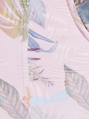 Close-up of the Sonya Bustier, crafted from light pink lightweight twill with a subtle palm leaf print and a colorful floral pattern in soft green, purple, yellow, and blue.