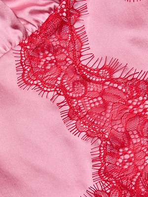 Close-up of the Kimber Silk Lace Camisole in pink satin, showcasing a red lace trim with intricate floral patterns and fringed edges.