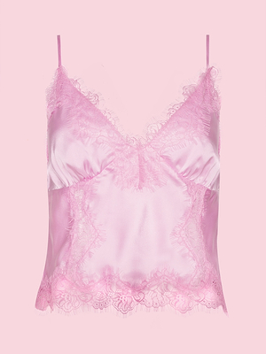The Kimber Silk Lace Camisole from the Legally Blonde capsule, crafted in pink satin with lace trim at the neckline and hem and thin adjustable straps, is showcased on a solid pink background.