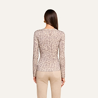A woman with straight brown hair is shown from the back against a plain light background wearing the Tess Long Sleeve Tee—a slim fit, long-sleeve grey leopard print top—paired with beige pants.