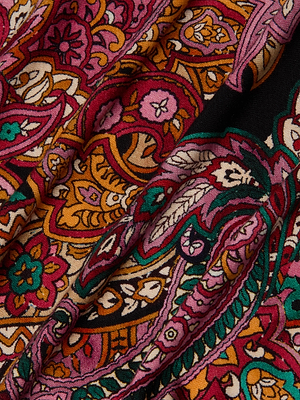 A close-up of the Ressi Fitted Tee by L'AGENCE shows vibrant paisley print stretch jersey in swirling red, pink, orange, yellow, green, and black tones. The soft fabric is slightly wrinkled and ideal for a short sleeve tee.