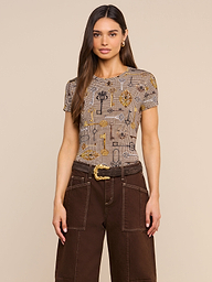 Wearing the bestselling Ressi Fitted Tee with a brown houndstooth pattern, a woman with long brown hair pairs it with wide-leg brown pants featuring white stitching and a belted waist, standing against a plain light background.
