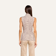 A woman stands with her back to the camera, wearing the Ceci Sleeveless Turtleneck in a light brown animal print and beige pants, set against a plain light background.