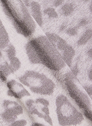 Close-up of the Ceci Sleeveless Turtleneck, showcasing its soft fabric in a grey leopard print pattern with diagonal folds—perfect for a slim fit.