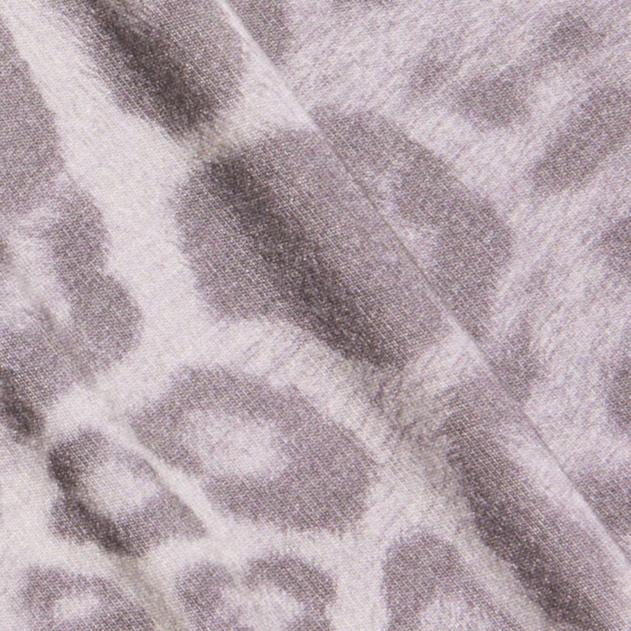 Close-up of the Ceci Sleeveless Turtleneck in grey leopard print fabric, featuring a soft, textured surface and irregular circular patterns.