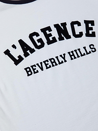 Close-up of the Tommie Crewneck Tee, a white shirt made from Supima cotton with bold black LAGENCE text and BEVERLY HILLS in smaller letters below.