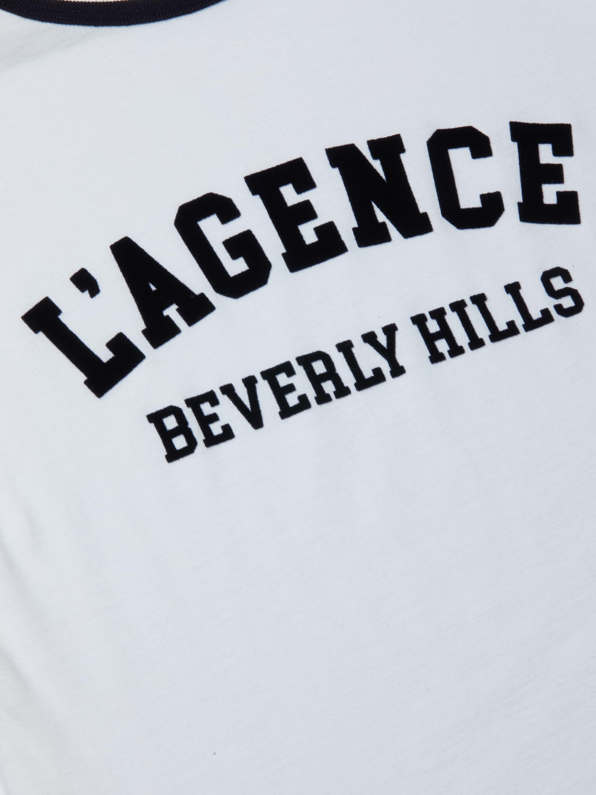 Close-up of the Tommie Crewneck Tee, a white shirt made from Supima cotton with bold black LAGENCE text and BEVERLY HILLS in smaller letters below.