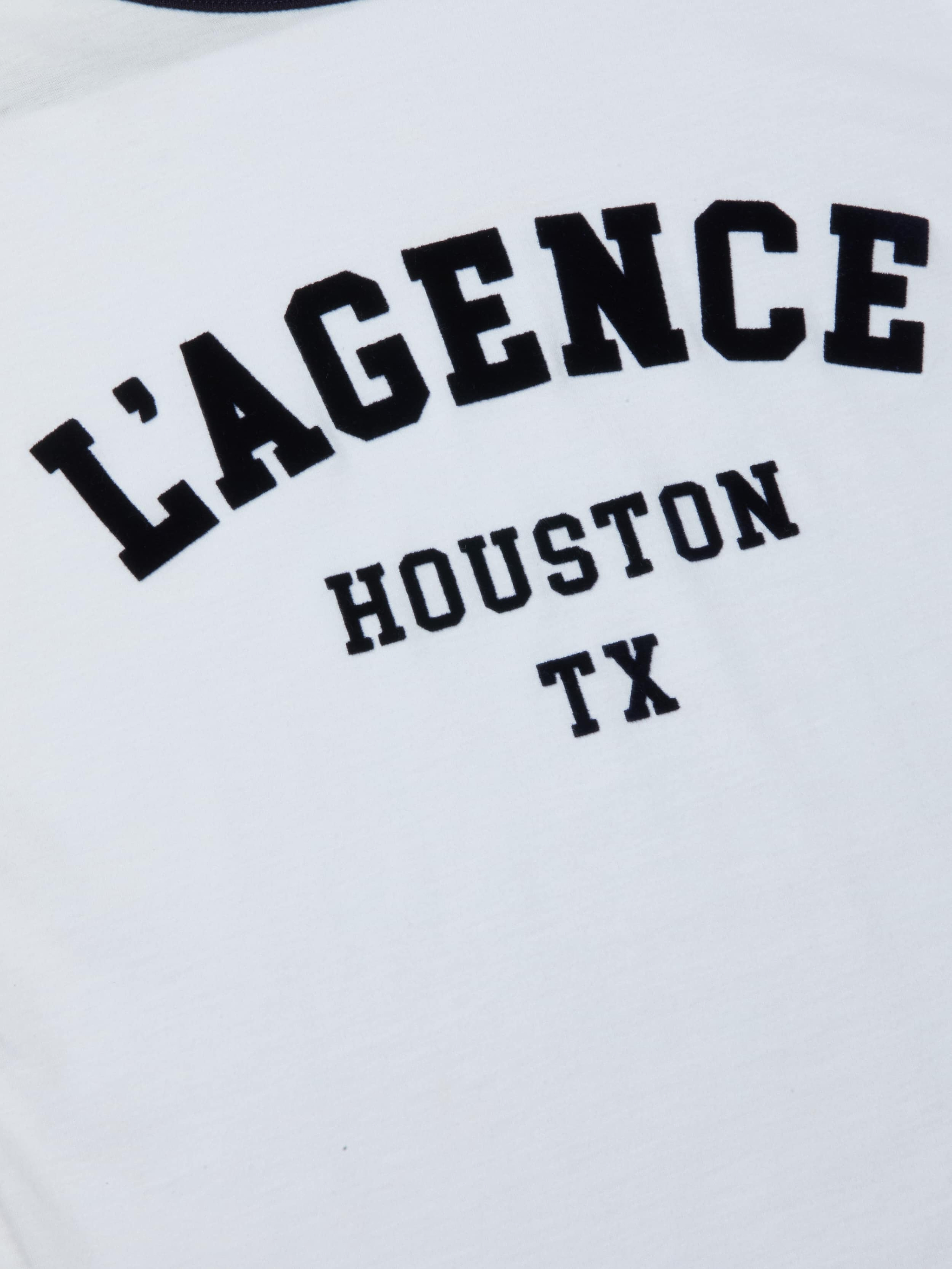 The Tommie Crewneck Tee is a white Houston t-shirt featuring bold black “LAGENCE” lettering above smaller “HOUSTON TX” text, crafted from soft Supima cotton in a relaxed fit.