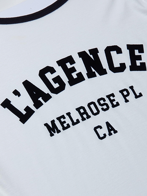 The Tommie Crewneck Tee features white Supima cotton with bold black LAGENCE MELROSE PL CA text in large, athletic-style letters across the front.