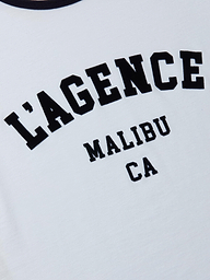 Close-up of the Tommie Crewneck Tee, a white ringer made from soft Supima cotton, featuring bold black LAGENCE MALIBU CA text in an athletic collegiate font.