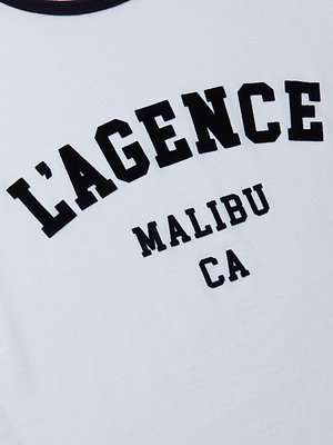Close-up of the Tommie Crewneck Tee, a white ringer made from soft Supima cotton, featuring bold black LAGENCE MALIBU CA text in an athletic collegiate font.