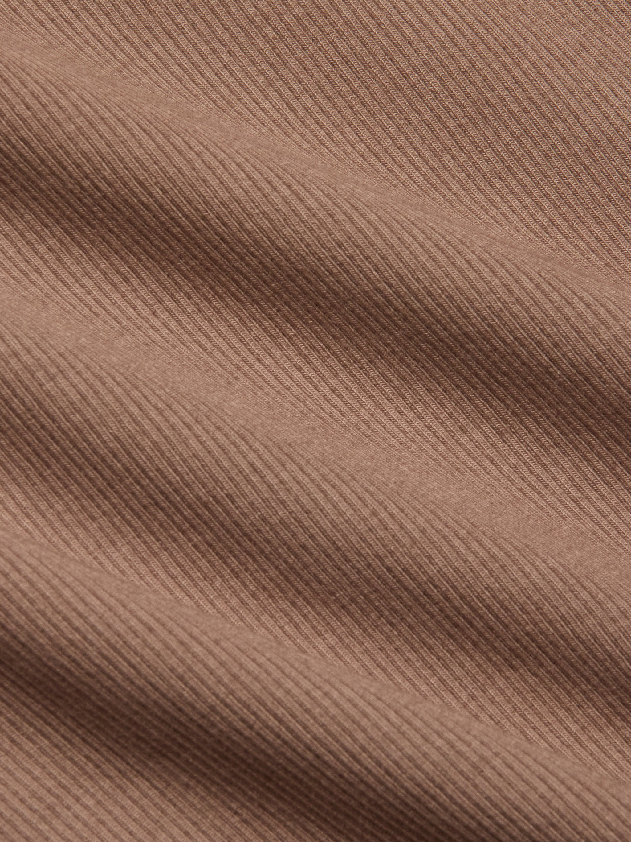 Close-up of the Adira Scoopneck Tank in brown, featuring stretch rib fabric with diagonal textured lines and soft shadows that highlight the material’s weave and surface detail.