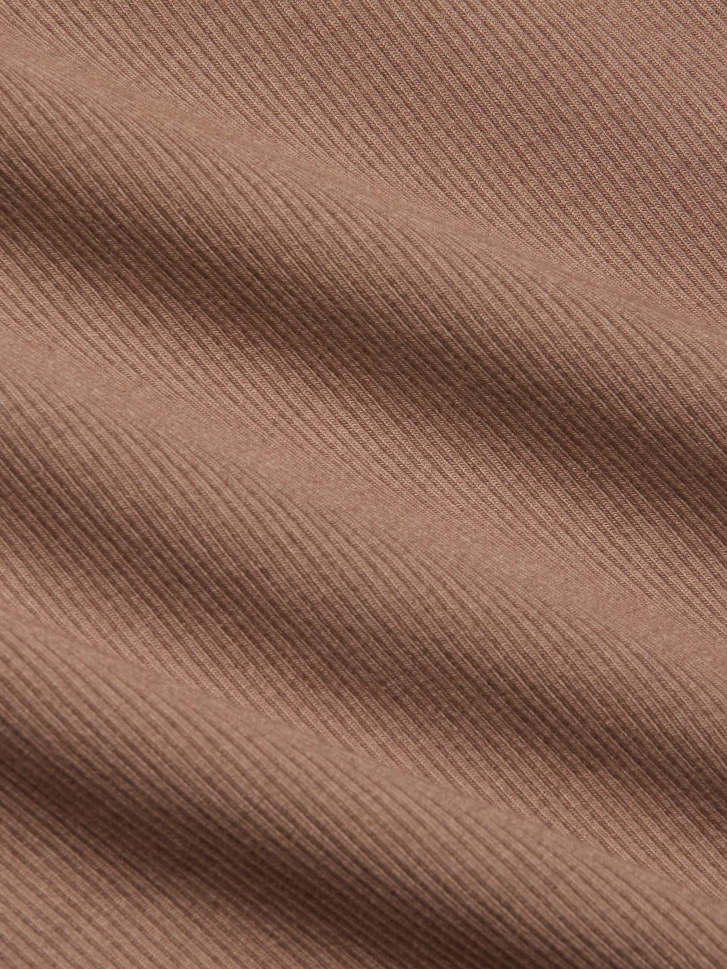 Close-up of the Adira Scoopneck Tank in brown, featuring stretch rib fabric with diagonal textured lines and soft shadows that highlight the material’s weave and surface detail.