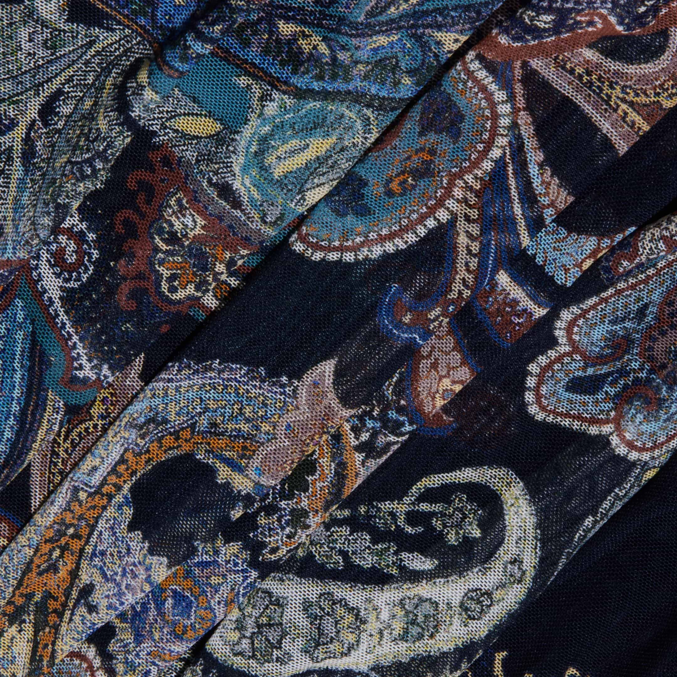The Rasha Shirred Mesh Tank features a dark fabric adorned with an intricate paisley pattern in blue, teal, orange, and cream, highlighting swirling shapes and floral details. Designed with a square neckline for versatility, this women’s top showcases elegantly folded mesh that creates overlapping sections and textured dimension.