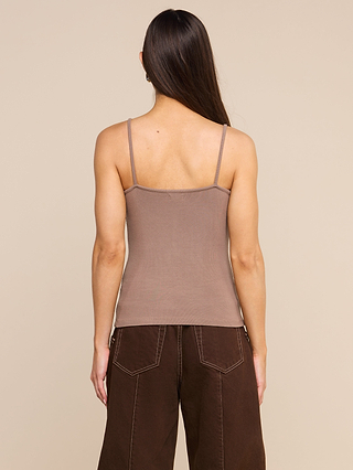 A person with long brown hair is shown from the back, wearing the Lunara Camisole in taupe ribbed fabric and dark brown wide-leg pants against a beige background.