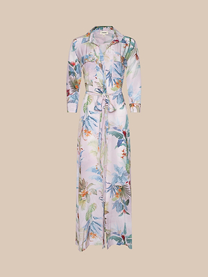 The Cameron Silk Shirt Dress, displayed against a beige backdrop, features a tie belt and a vibrant palm leaf print in blue, green, orange, and red on light silk.