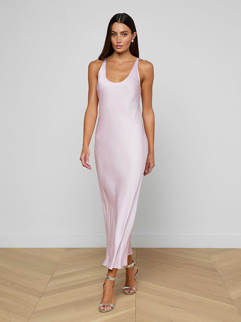 A woman wearing the Akiya Satin Maxi Dress in pastel lilac and strappy heels walks confidently against a plain white background.