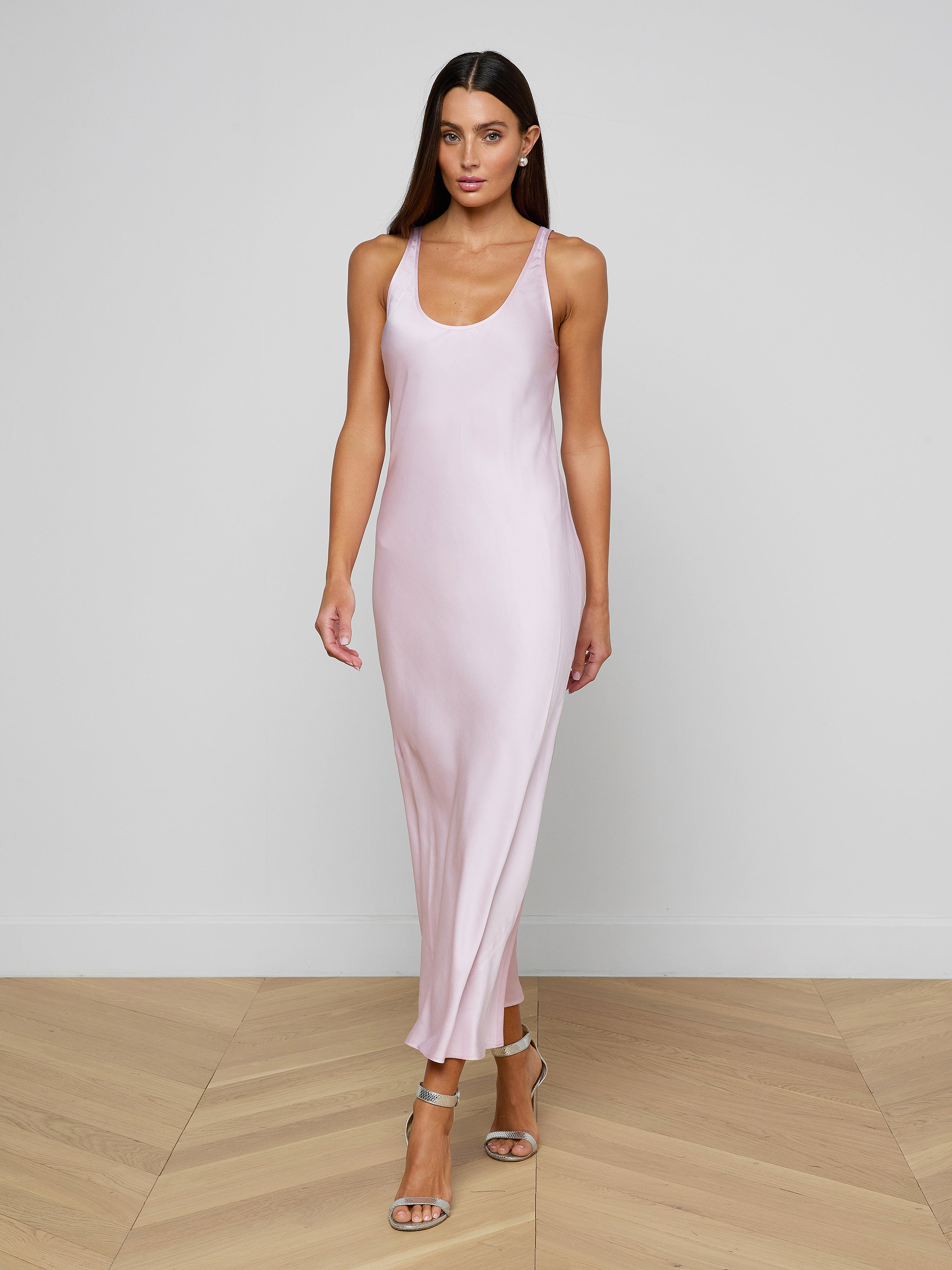 A woman wearing the Akiya Satin Maxi Dress in pastel lilac and strappy heels walks confidently against a plain white background.