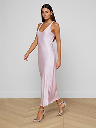 Wearing the Akiya Satin Maxi Dress in a sleeveless, pastel lilac design, a woman in strappy heels walks confidently against a plain, light background.