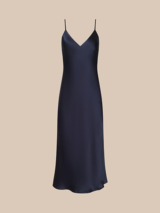 The Seridie Silk Slip Dress is a sleeveless, navy blue satin slip dress featuring thin spaghetti straps and a V-neckline, making it a chic choice for wedding guests. It is displayed on a plain beige background.