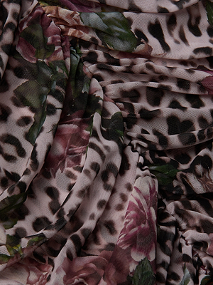 The Caprice Midi Dress features sheer fabric with a rose cheetah print—leopard spots and bold dark pink roses with green accents—draped gracefully in soft folds.