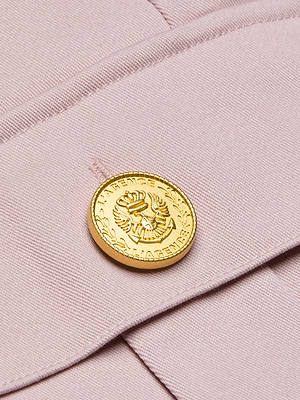 Close-up of a gold button with an embossed eagle and laurel design engraved with 