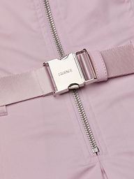 A close-up of the Kolton Dress features a pastel lilac statement belt with a shiny silver buckle engraved with LAGENCE, situated next to a silver zipper on matching pink fabric.
