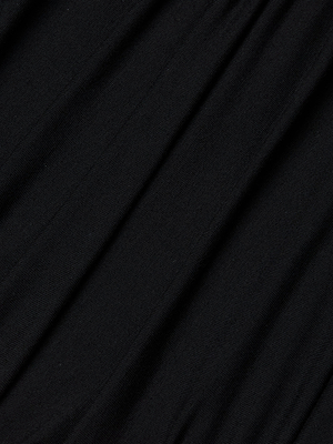 A close-up of the Paityn Shirred Dress in black stretch jersey, showcasing soft folds and a subtle textured surface with diagonal lines.