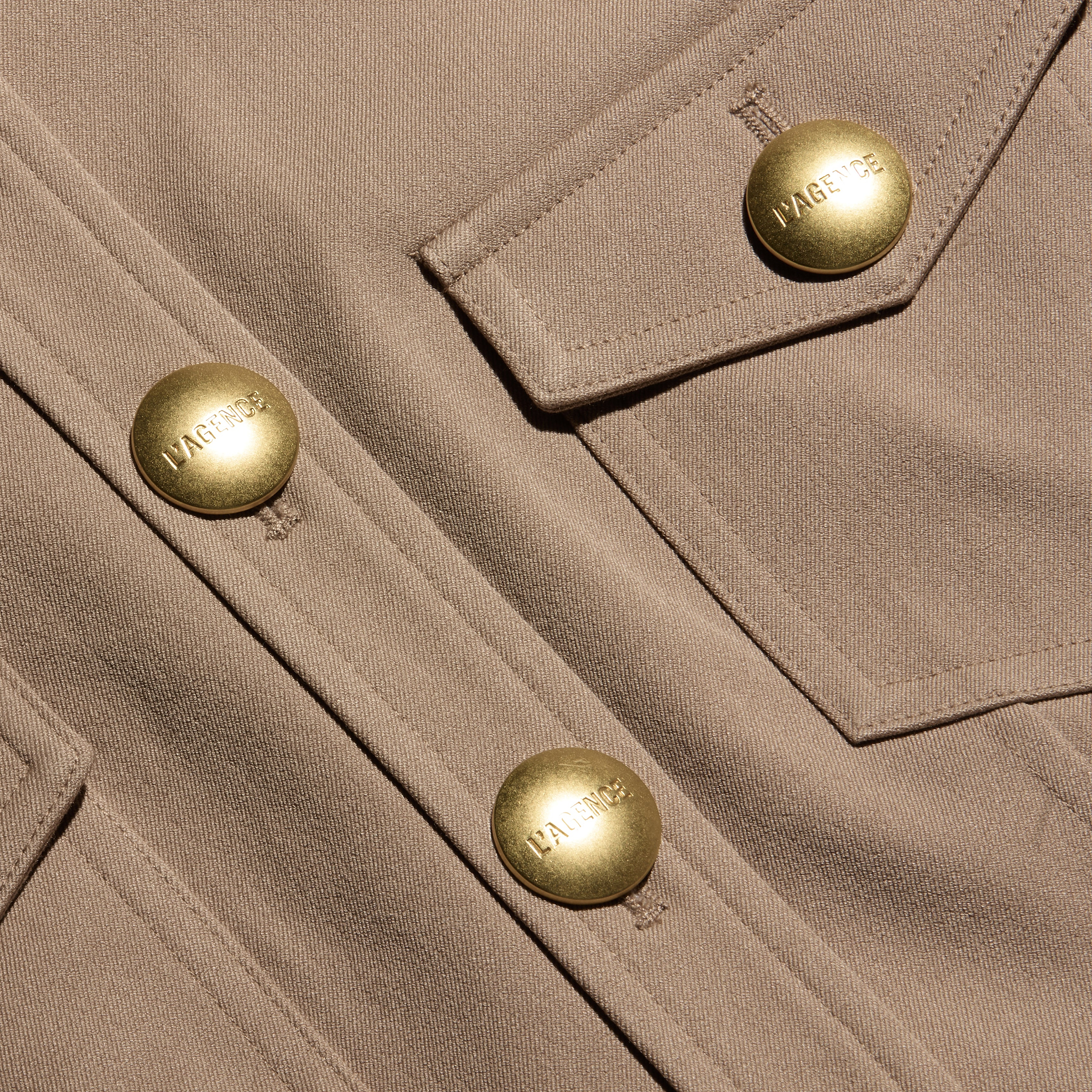 Tan stretch twill Cori mini dress featuring large gold-tone hardware buttons on the front placket and chest pocket flap.