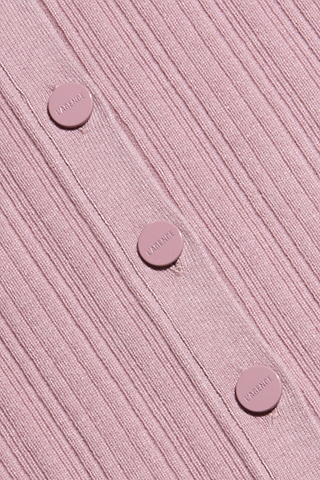 Primo piano su un tessuto rosa a coste del Domino Dress, un abito midi senza maniche, impreziosito da quattro bottoni rosa con la scritta “LAVERNE” incisa in fila verticale.