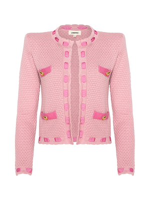 The Astor Cardigan by L'AGENCE is a Parisian-inspired light pink textured knit with long sleeves, four front pockets, gold buttons, and darker pink trim on the edges and pockets.