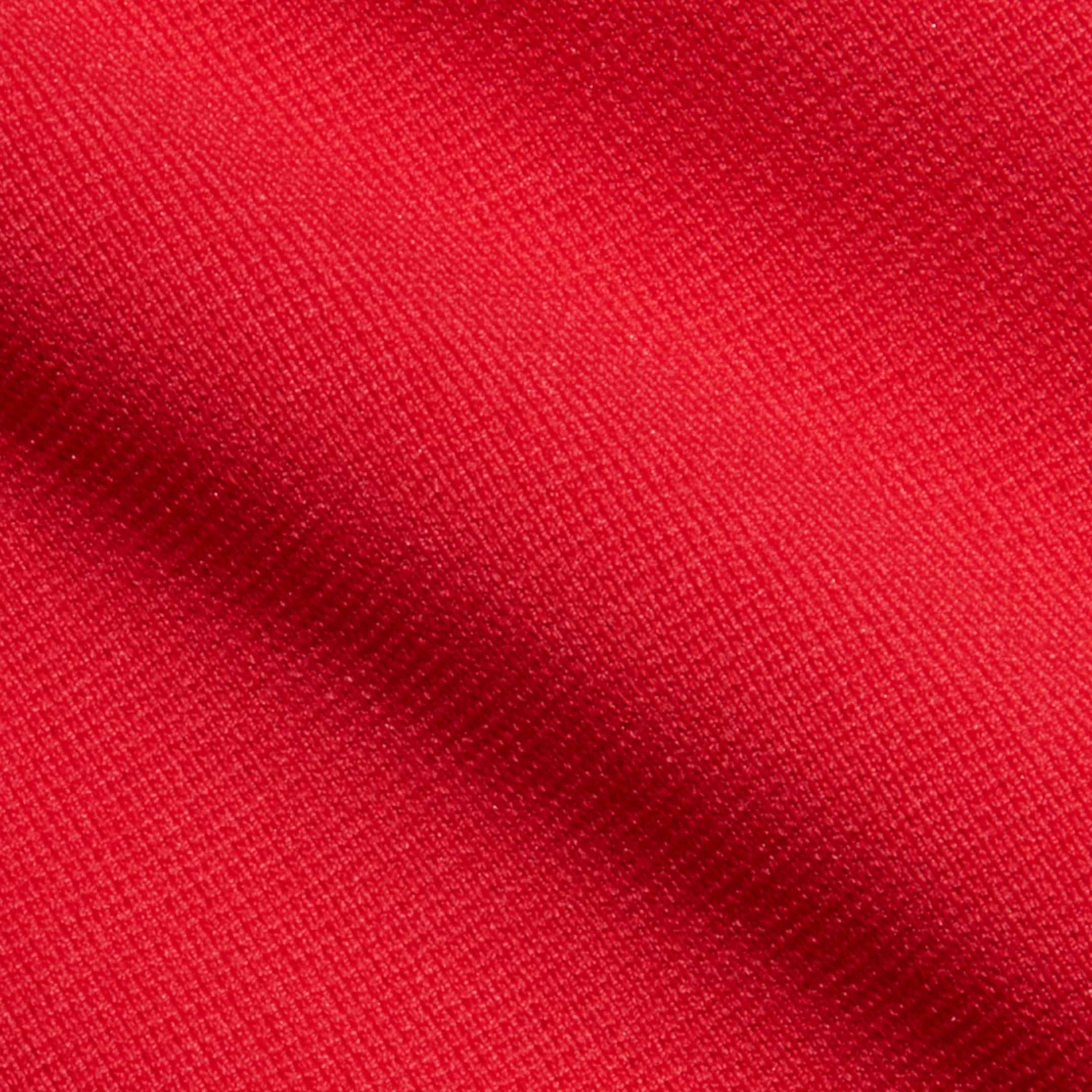 Close-up of lipstick red fabric from the Romona Knit Dress, featuring a visible woven texture and a slight diagonal fold that highlights the fine threads and vibrant color.
