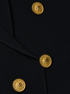 Close-up of the L'AGENCE Elio Cropped Knit Blazer in black, featuring three shiny gold embossed buttons arranged diagonally for a sophisticated touch on its textured knit fabric.