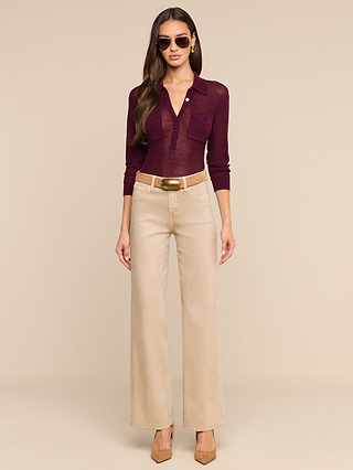 Woman wearing sunglasses, a burgundy Carine Top in lightweight knit, beige wide-leg pants with utility pockets and a tan belt, and beige heels, standing against a neutral background.