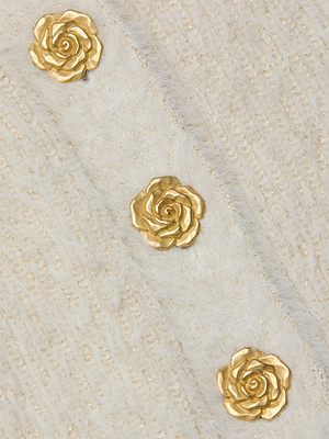 Three gold rose-shaped embellishments are arranged diagonally on the soft, off-white fuzzy knit of the Talulla Cardigan by L'AGENCE, featuring a subtle striped pattern and a cozy, stylish look.