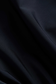 Close-up of smooth, dark navy blue fabric with soft folds and gentle light reflections highlighting the texture, reminiscent of the versatile Nicole Bikini Bottom.