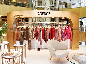 Fashion store interior with 'L'AGENCE' branding and clothing display.