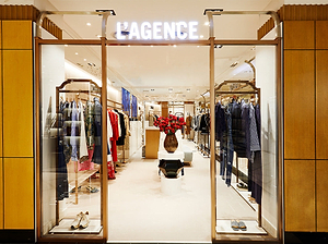 Store interior with 'L'Agence' sign and clothing display