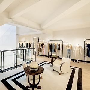 Modern clothing store interior with racks of clothes and a stylish decor.