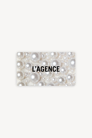 A rectangular card with a background of variously sized white pearls and the black text L’AGENCE centered on it.