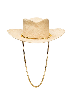 The Zamora Cowboy Hat is a beige woven-straw piece handcrafted in LA, featuring a wide brim, gold chain crown detail, and a matching gold chin strap.