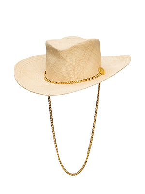 The Zamora Cowboy Hat features a wide-brimmed, light tan woven-straw design with a gold chain band, matching chin strap, and the iconic L'AGENCE lion head logo.