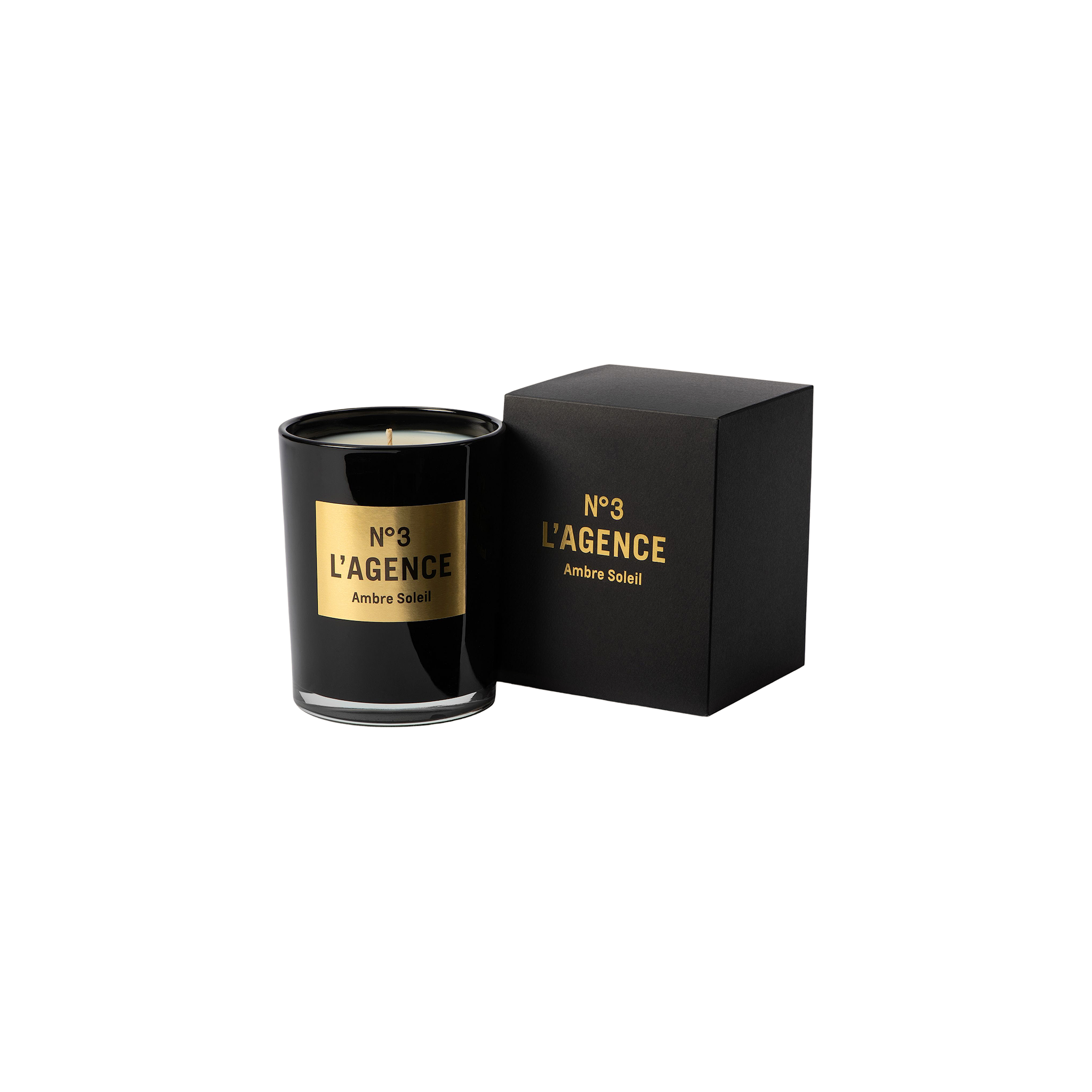 A black Ambre Soleil candle, adorned with gold accents and matching label, is displayed next to its coordinating black and gold box on a light background. This sophisticated candle is part of our hand-poured collection, thoughtfully crafted for a clean, even burn.
