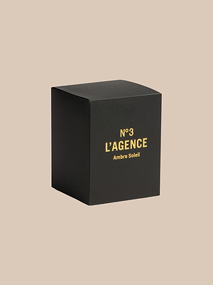 A black box labeled Ambre Soleil sits on a beige background, highlighting the elegance of hand-poured Southern California candles.